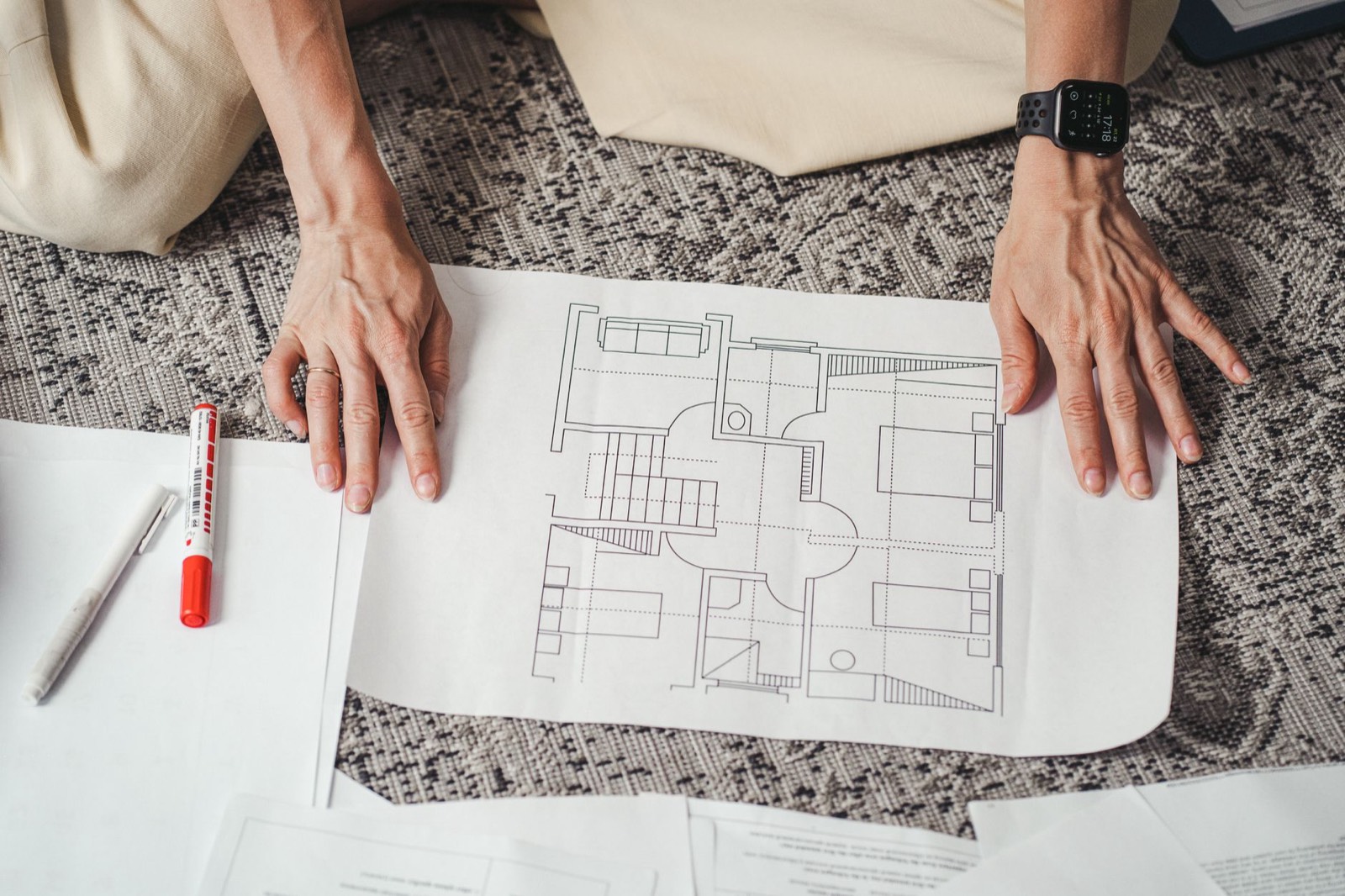Plan d'architecte d'un logement posé sur un bureau avec instruments de dessin